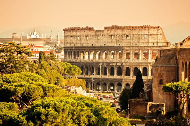 A dramatic upward-facing shot of the Roman Colosseum, showcasing its ancient arches, weathered stone textures, and architectural grandeur. This image emphasizes the sheer scale and engineering brilliance of the historic amphitheater, symbolizing the power and endurance of Ancient Rome. Sunlight cuts through the shadows between the tiers of arches, highlighting the craftsmanship of this iconic World Heritage site.