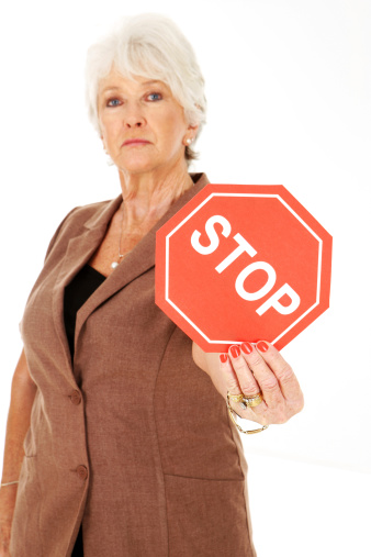 Mature woman holding stop sign