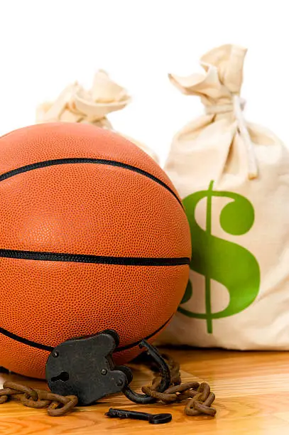 Concept-NBA Lockout. Basketaball sitting on hardwood court with a money bag chain and padlock