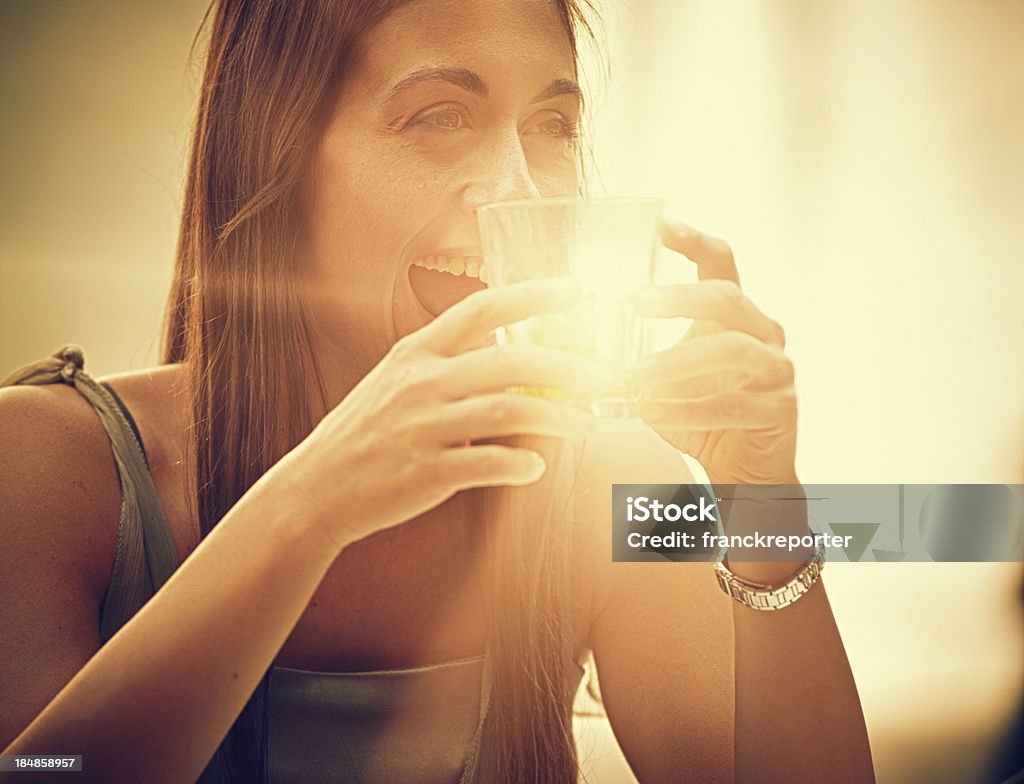 Mujer beber un cóctel sin alcohol con luz en el vidrio - Foto de stock de 20-24 años libre de derechos