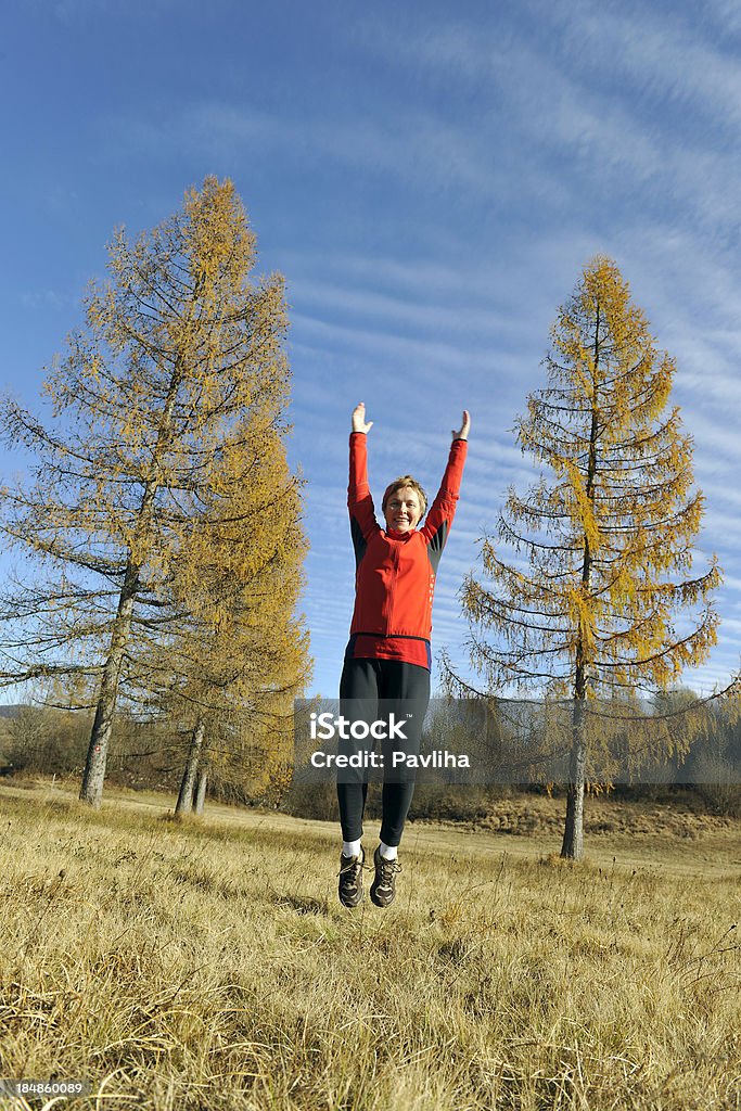 Frau in Rot Jumping Herbst - Lizenzfrei Aktiver Lebensstil Stock-Foto