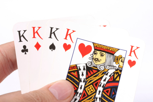 Hand of four Kings playing cards isolated on white background.