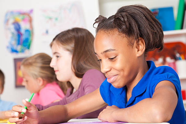 istock Little girl smiling while painting in art class at school 184860478