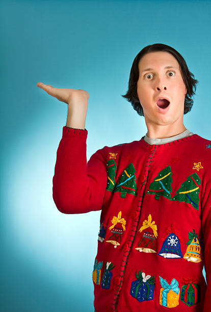 Look what I have Young ugly sweater man holding nothing christmas ugliness sweater nerd stock pictures, royalty-free photos & images