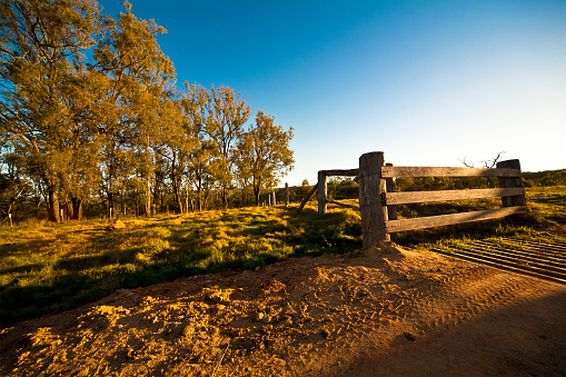Wide angle image of rustic gate in rural Australian farmland.