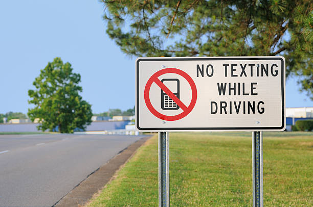 istock Road sign reading no texting while driving with cell phone 184861350