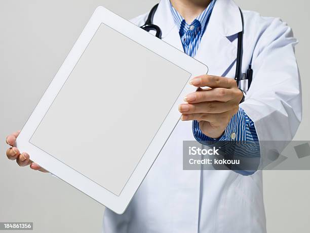 Médico Examina Mediante El Uso De Tablet Pc Móvil Foto de stock y más banco de imágenes de Agarrar - Agarrar, Artículo médico, Asistencia sanitaria y medicina