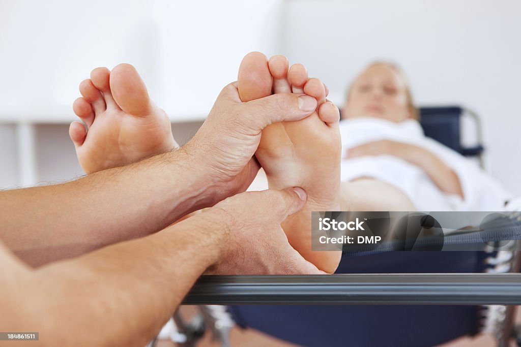 Donna incinta fare un massaggio ai piedi - Foto stock royalty-free di Massaggio dei piedi
