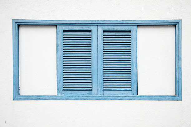 istock two blue window shades in white spanish housing facade 184861538