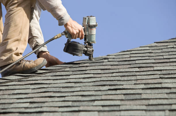 Roofer Nailing Cap Shingle to a New House Roof stock photo