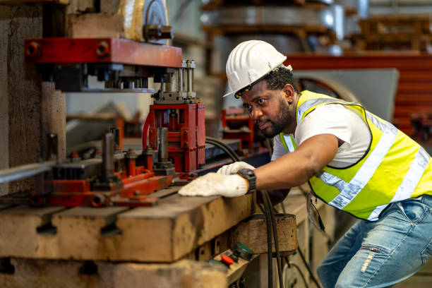 istock African American industrial worker is using hydraulic power press machine to make metal and steel part while working inside the metal sheet galvanized roof factory for safety industry 1848629035