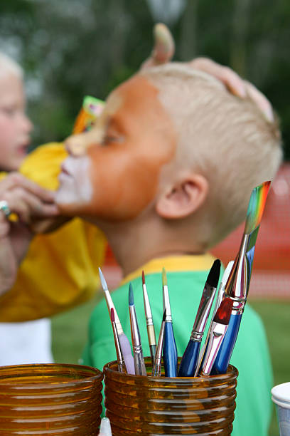 Kid getting face painted stock photo
