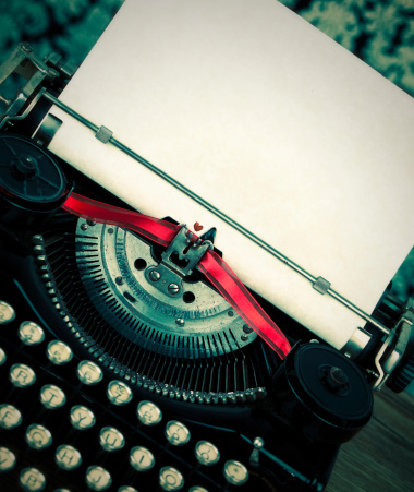 Cross-processed image of a vintage typewriter with red ribbon and a heart printed on the paper to suggest the concept Love to Write or writing a Love Story.