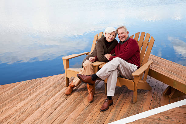 istock Senior couple sitting by water 184864083