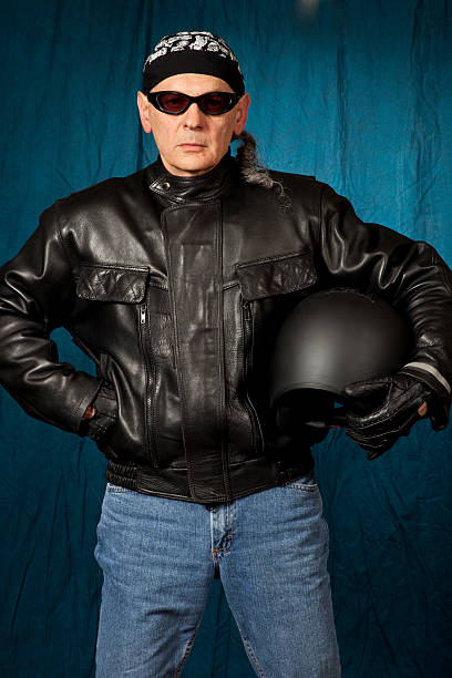 istock Biker with pony tail holding helmet, sun glasses, doo rag 184864284