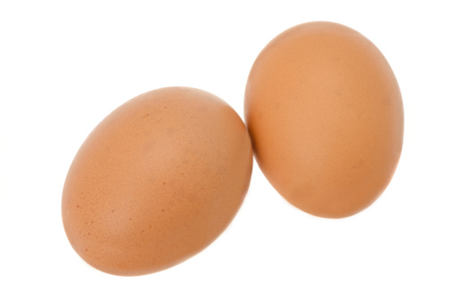 Two fresh chicken eggs - studio shot with a white background