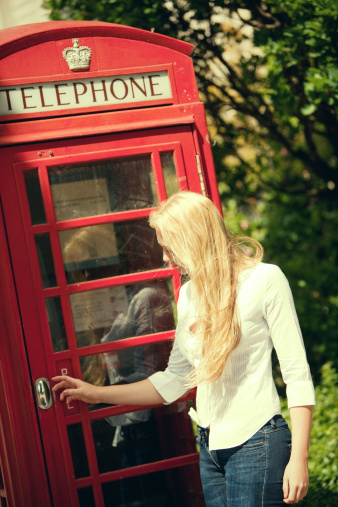 Young Woman using Red Phone booth in London