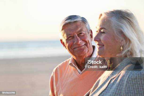 Senior Par De Pie En La Playa Foto de stock y más banco de imágenes de Pareja mayor - Pareja mayor, Perfil - Vista de costado, 60-69 años