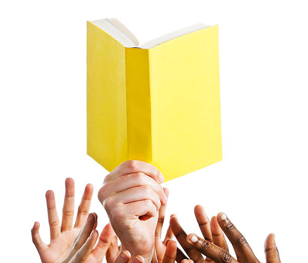 istock Mixed hands reach for blank yellow book against white 184865644