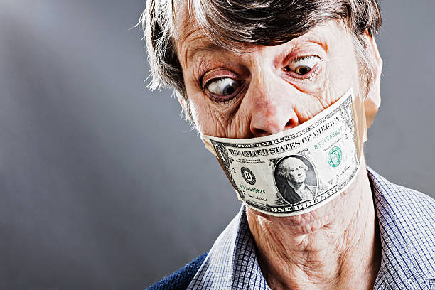 peine vieille femme regarde en bas vers dollars canadiens bâillonner son - currency silence censorship behavior photos et images de collection