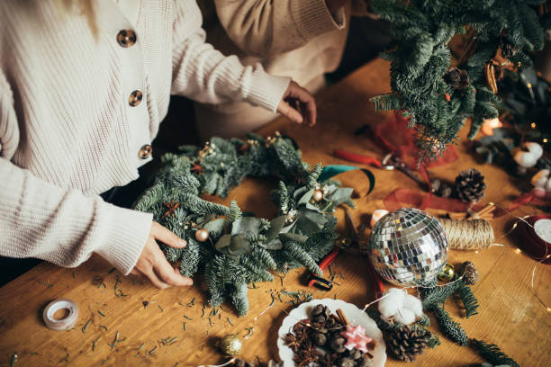 istock Happy women making Christmas wreath using natural pine branches and festive decorations. 1848661953