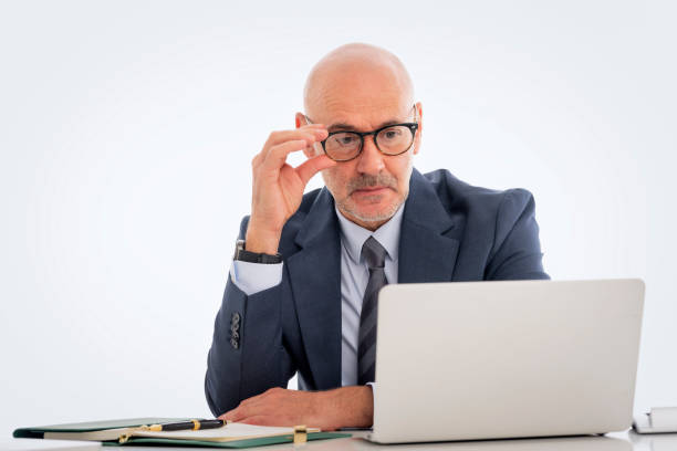 istock Mid aged businessman sitting at desk and using notebook for work against isolated background 1848665580