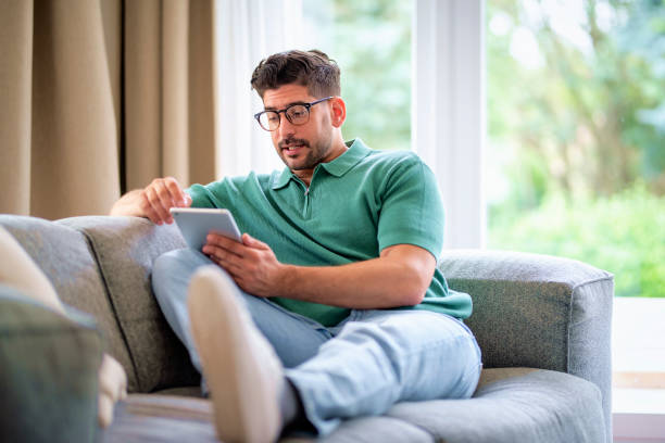 istock Mid aged man sitting at home and using digital tablet 1848668817