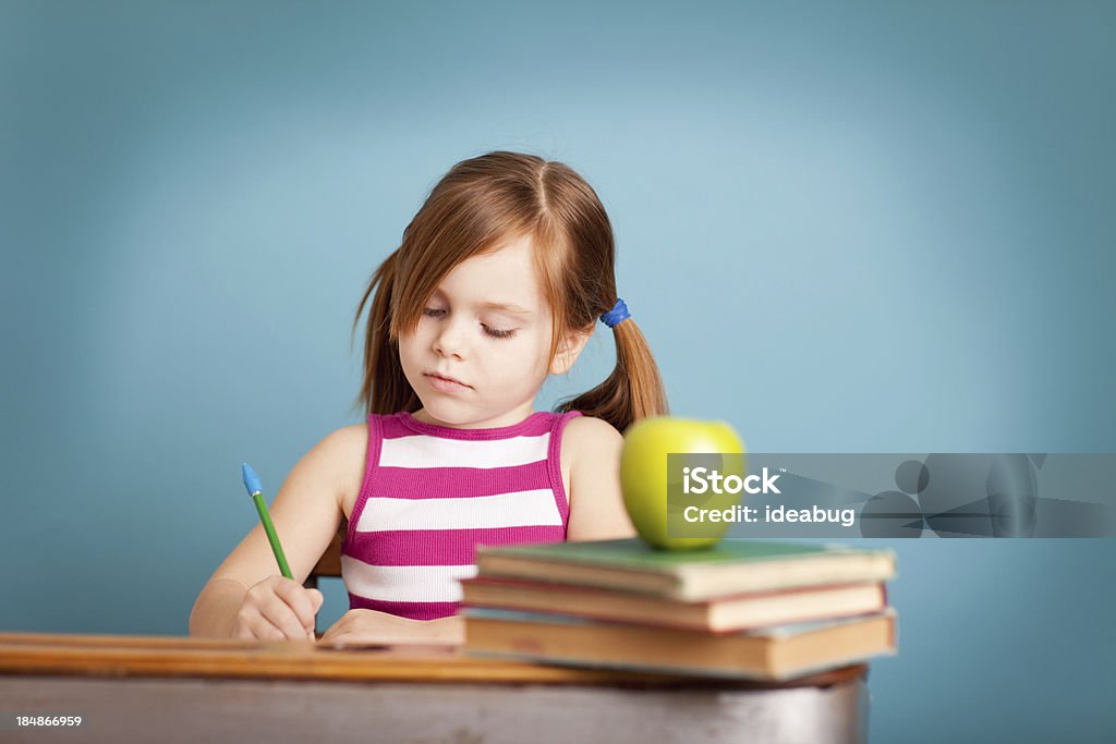 Grave jovem estudante sentado à mesa a fazer um trabalho - Royalty-free 4-5 Anos Foto de stock