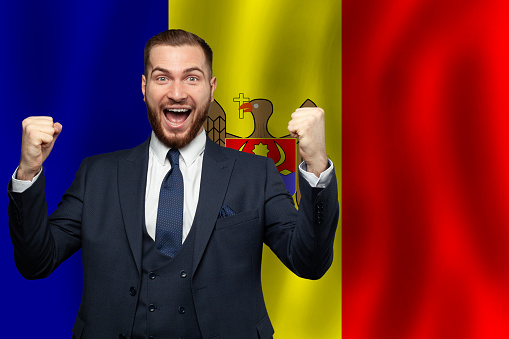 Moldovan happy businessman on the background of flag of Moldova Business, education, degree and citizenship concept