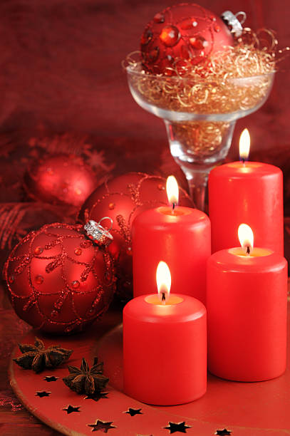istock four burning Advent candles with Christmas red ornaments 184867430