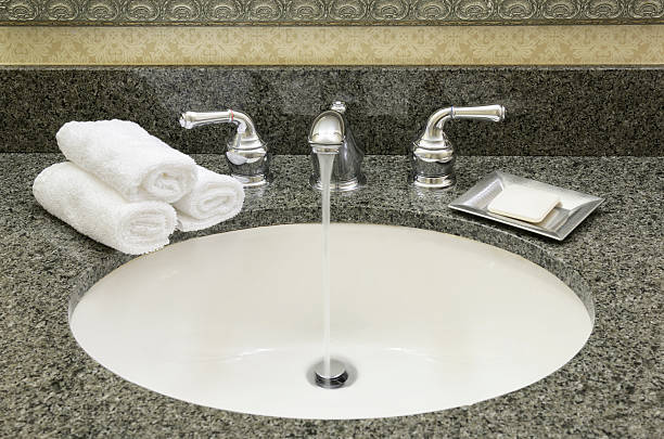 istock Bathroom sink, water flowing from open faucet 184867439