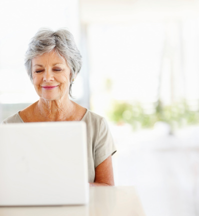 Happy mature woman using a laptop at home