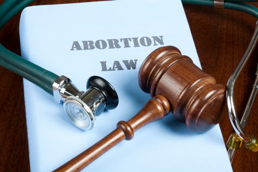 Gavel and stethoscope on Abortion law handbook.