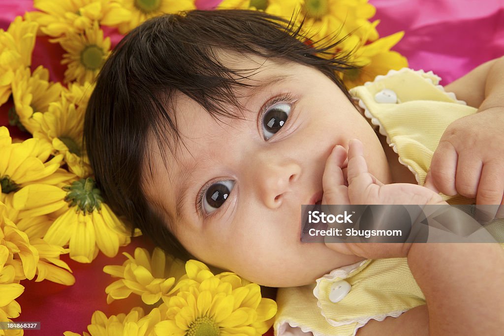 Dolce bambina con grandi Occhi marroni e fiori - Foto stock royalty-free di 0-1 Mese