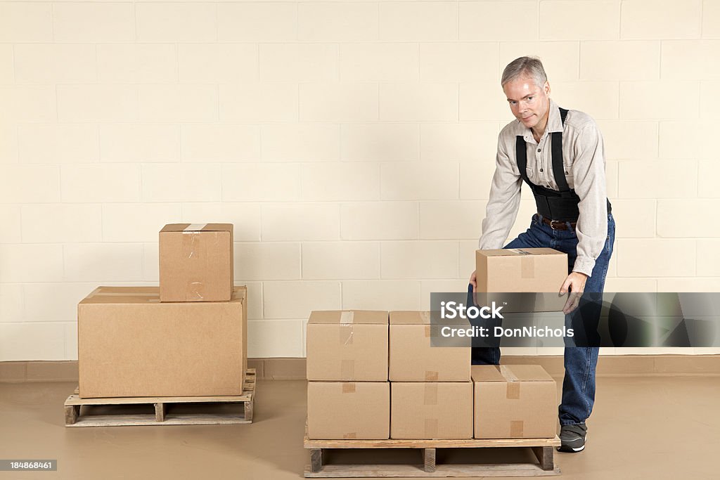 Worker Wearing a Back Brace Worker wearing a back brace while moving boxes.Please also see: Picking Up Stock Photo