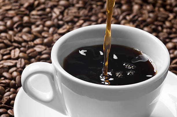 el vertido corriente de una taza de café en blanco, marrón - caffeine full frame studio shot horizontal fotografías e imágenes de stock
