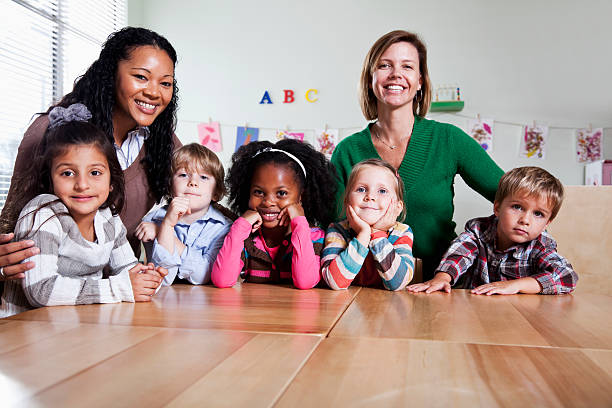 Multi-ethnic preschool children (3-4 years) with teachers in classroom.
