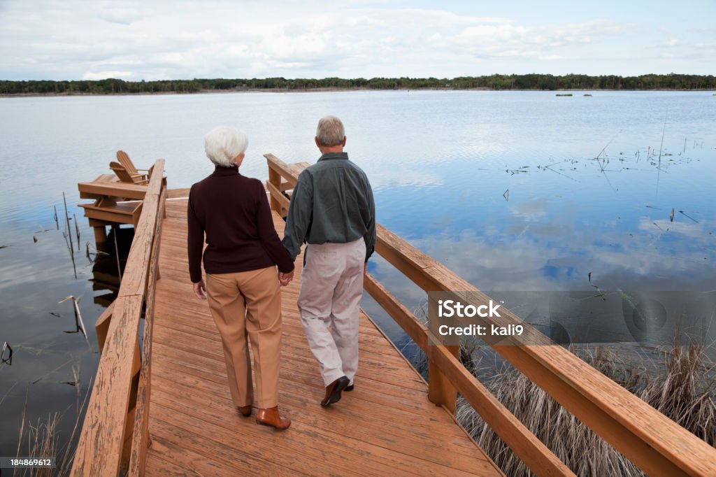 Senior couple debout au bord de l'eau - Photo de Admirer le paysage libre de droits