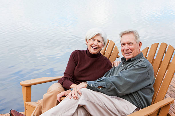 istock Senior couple sitting by water 184869614