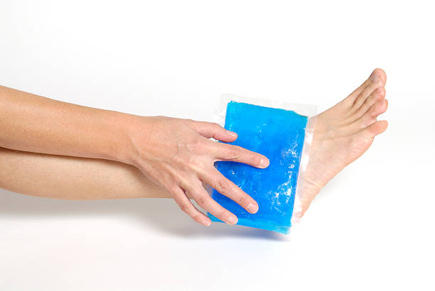 Blue gel pack applying on an ankle on white background stock photo