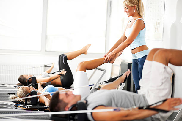 istock Coach assisiting the girl exercising on Pilates machine. 184870056