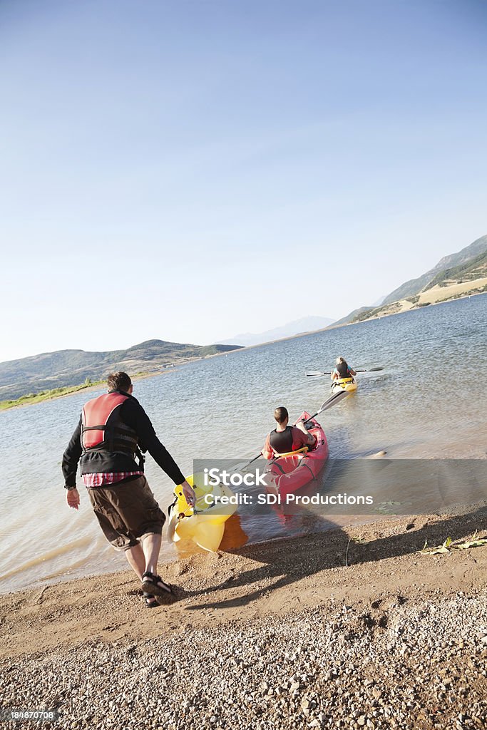 Kajakarzy przyjmowanie ich kajaki się na jezioro - Zbiór zdjęć royalty-free (Brzeg jeziora)