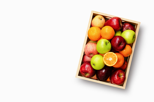 Apples and oranges fruit in wooden crate isolated on white background with clipping path, top view, flat lay.