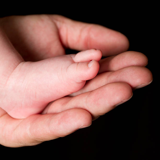 istock Newborn baby feet in father's hand 184871455