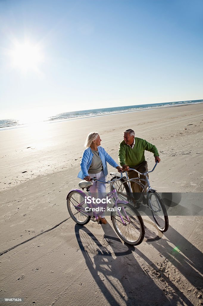 Senior couple with bicycles on beach Active senior couple (60s) with bicycles on beach. High Angle View Stock Photo