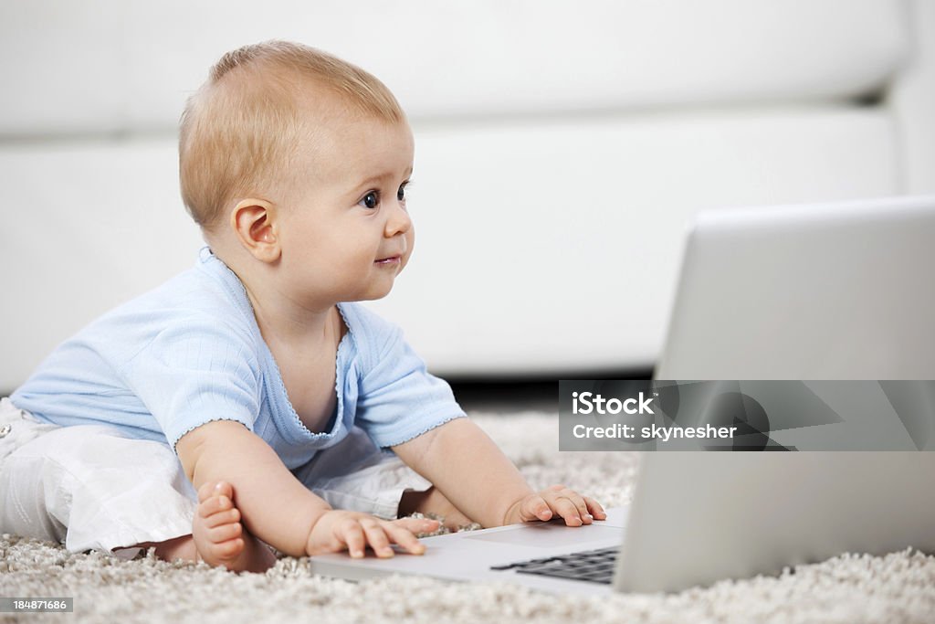 Bellissimo piccolo bambino e un computer portatile. - Foto stock royalty-free di Allegro