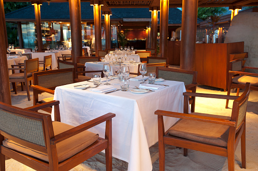 Beach restaurant at dusk with sand