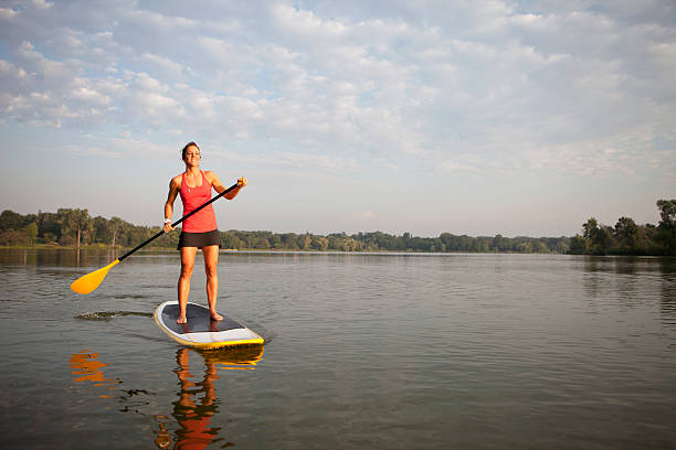 女性は、パドルボードをパドルボートで水に - paddleboard oar women lake ストックフォトと画像