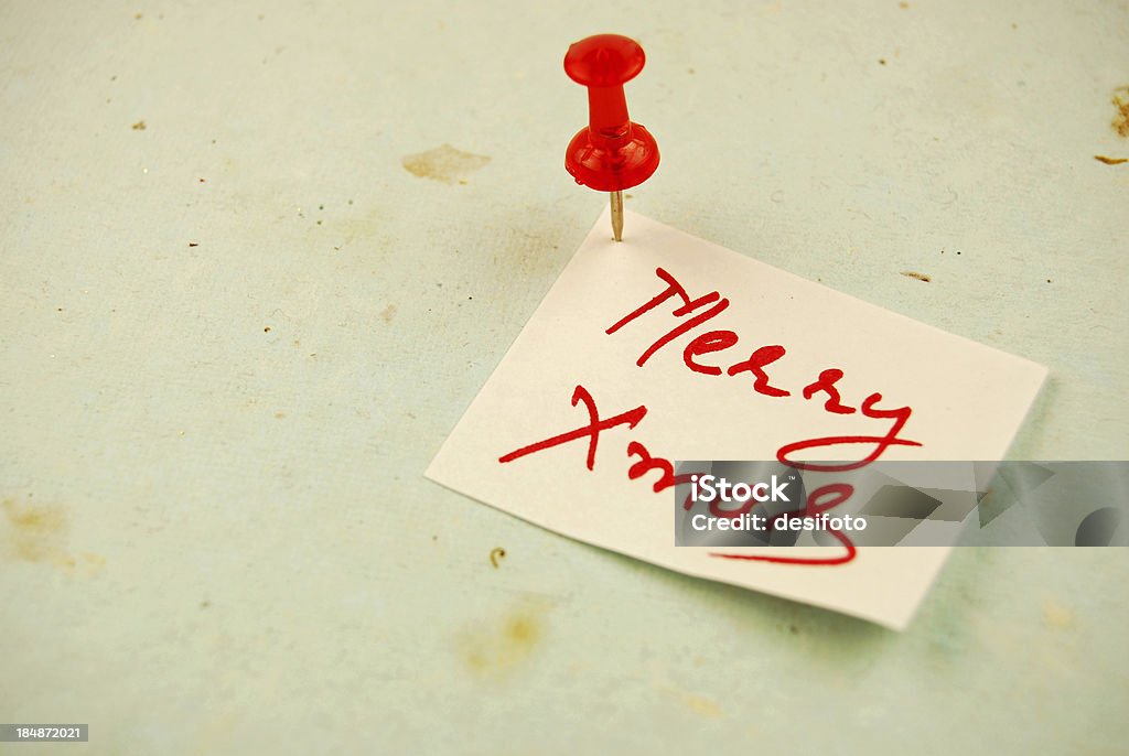 Merry Xmas "Note - Merry Xmas - fixed with a push pin over a rough, old, grungy surface." Celebration Event Stock Photo