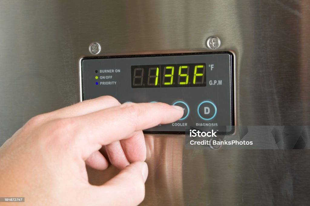 Maschio dito abbassare Tankless riscaldatore di acqua a temperatura - Foto stock royalty-free di Caldaia